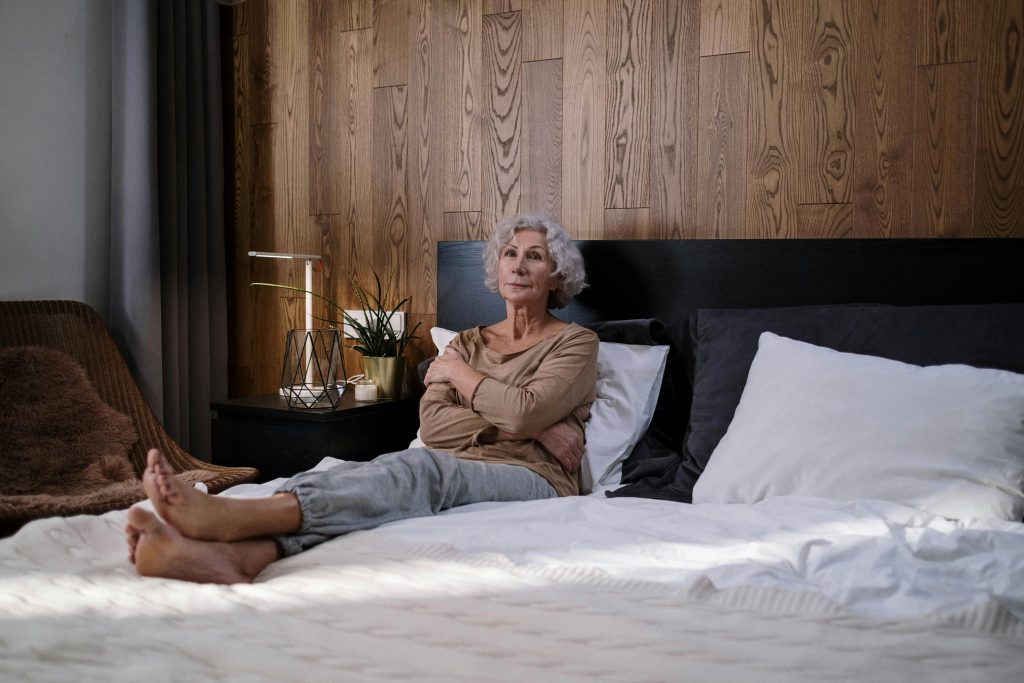 Ältere Frau auf Doppelbett